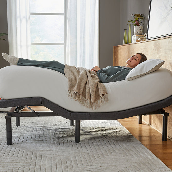 Woman laying asleep on a white mattress in a baselogic adjustable frame