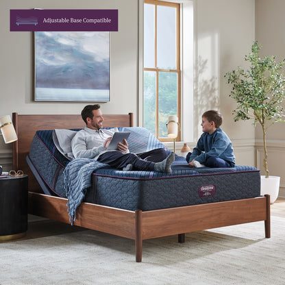 Man and his son sitting on a Beautyrest World Class mattress slightly elevated on an adjustable base sitting in a brown bed frame
