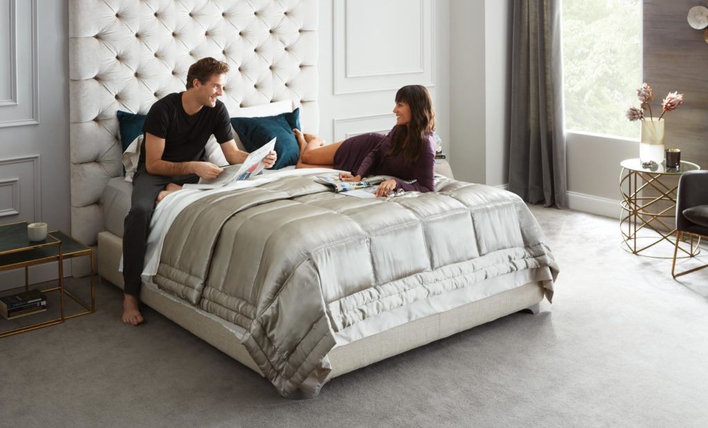 Couple sitting on a Beautyrest Black mattress.