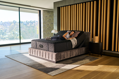 Woman laying asleep on a Beautyrest Black mattress sitting in a Beautyrest Black Luxury Base slightly elevated at the top